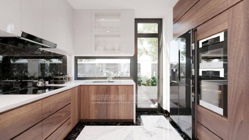 Là một trong những xu hướng trang trí nội thất nổi bật trong những năm tới, trang trí phòng bếp hiện đại tôn lên vẻ đẹp mộc mạc nhưng không kém phần sang trọng của gỗ điển hình là gỗ óc chó. Loại gỗ rất được ưa chuộng trong các siêu xe bởi vẻ đẹp ấn tượng từ vân, màu gỗ. Như trong ý tưởng trang trí phòng bếp tại biệt thự Vinhomes Imperia, sự hài hòa tôn lên nét đẹp giữa truyền thống và hiện đại, tủ bếp dưới gỗ óc chó và tủ bếp trên gỗ công nghiệp trắng bóng. Tủ bếp gỗ công nghiệp